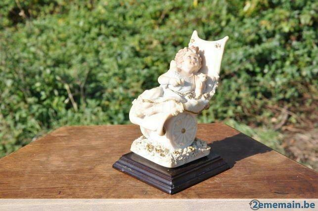 statuette style resine bambin dans caisse