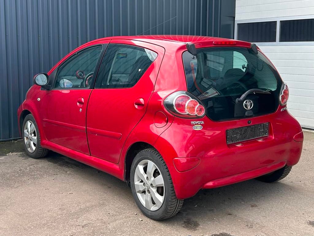 Toyota Aygo 1.0-12V Aspiration Red Navigator, Auto's, Toyota, Voorwielaandrijving, 4 zetels, Elektrische ramen, Alcantara