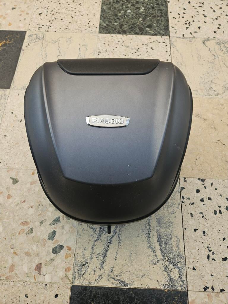 Kofferbak brommer merk Piaggio, Ophalen