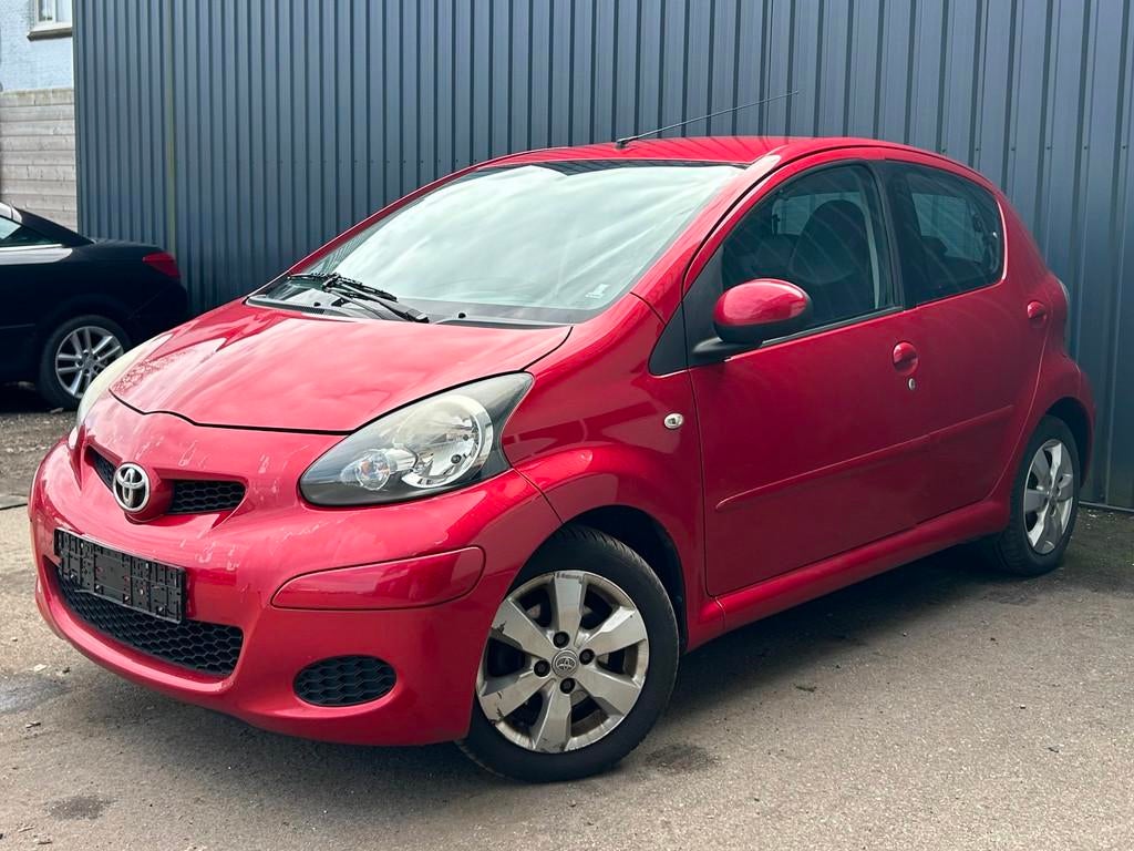 Toyota Aygo 1.0-12V Aspiration Red Navigator, Auto's, Toyota, Voorwielaandrijving, 4 zetels, Elektrische ramen, Alcantara