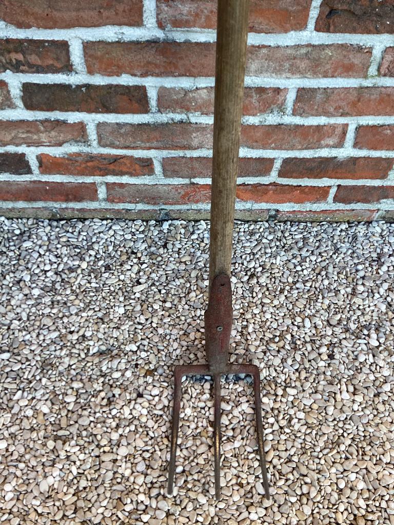 Een drietand tuinhark., Ophalen