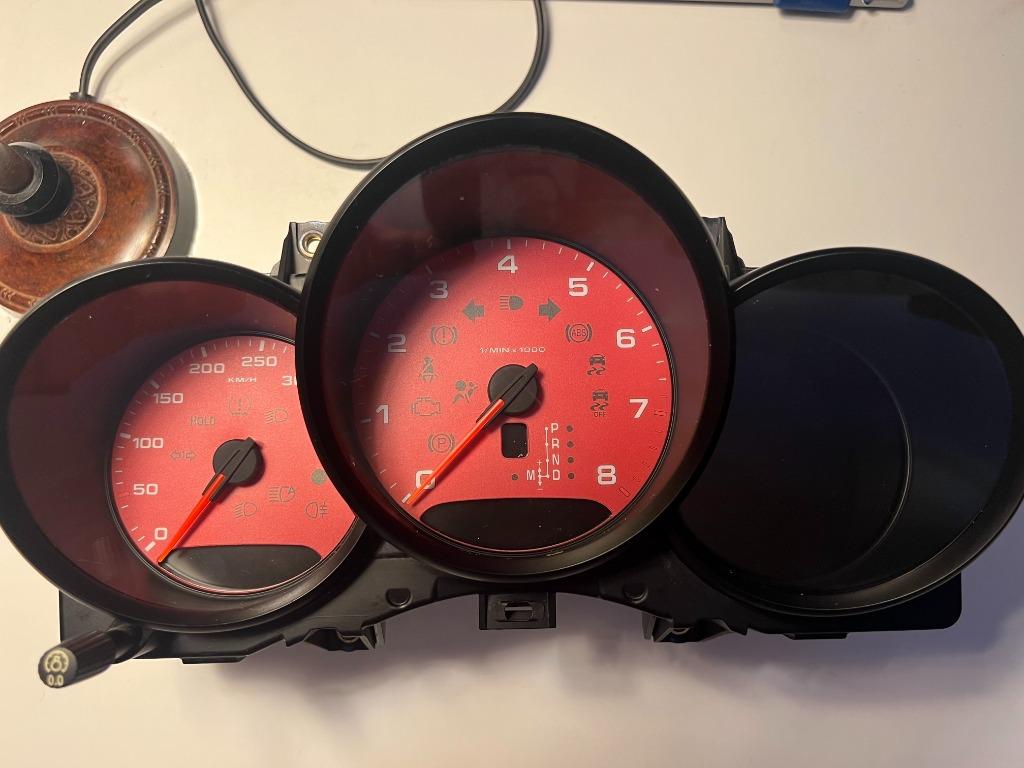 Porsche Cayman 718 982 kilometerteller met rode achtergrond, Ophalen of Verzenden, Porsche