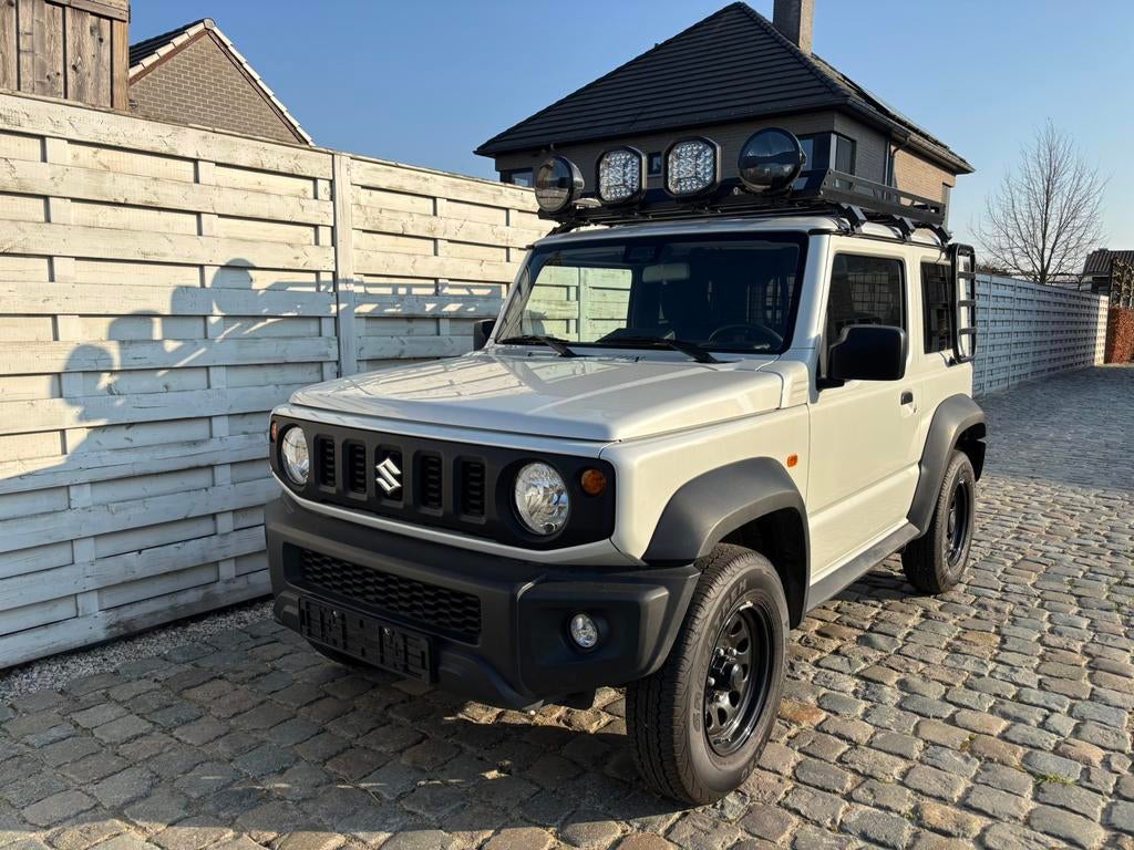 Suzuki Jimny 2024, 7 jaar garantie, pure white pearl, Auto's, Suzuki, 75 kW, 4 cilinders, Wit, Bedrijf