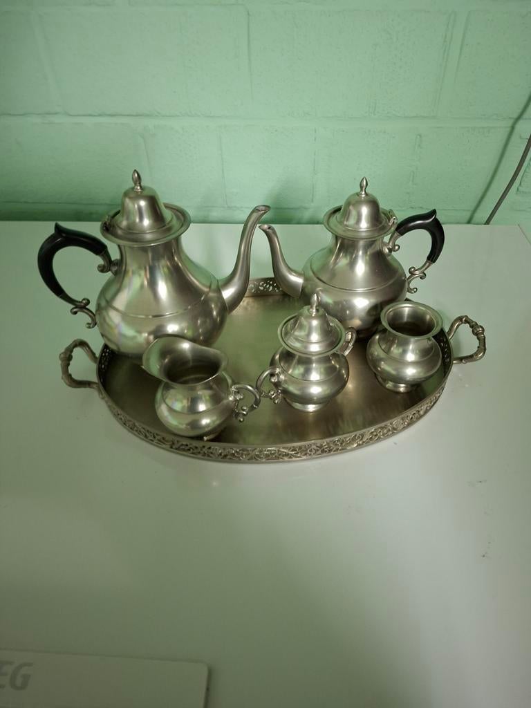 Een tinnen stel staat op serveerblad, Ophalen