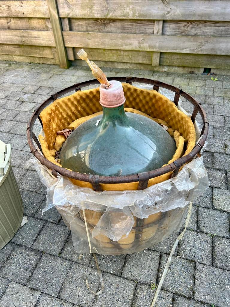 Dame Jeanne in metalen bescherm mand, Ophalen